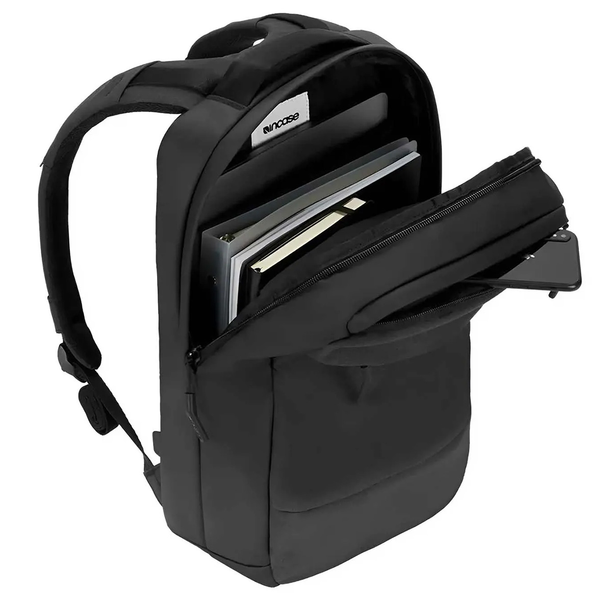Zaino nero con tasca anteriore aperta contenente un telefono e scomparto principale con libri e laptop.