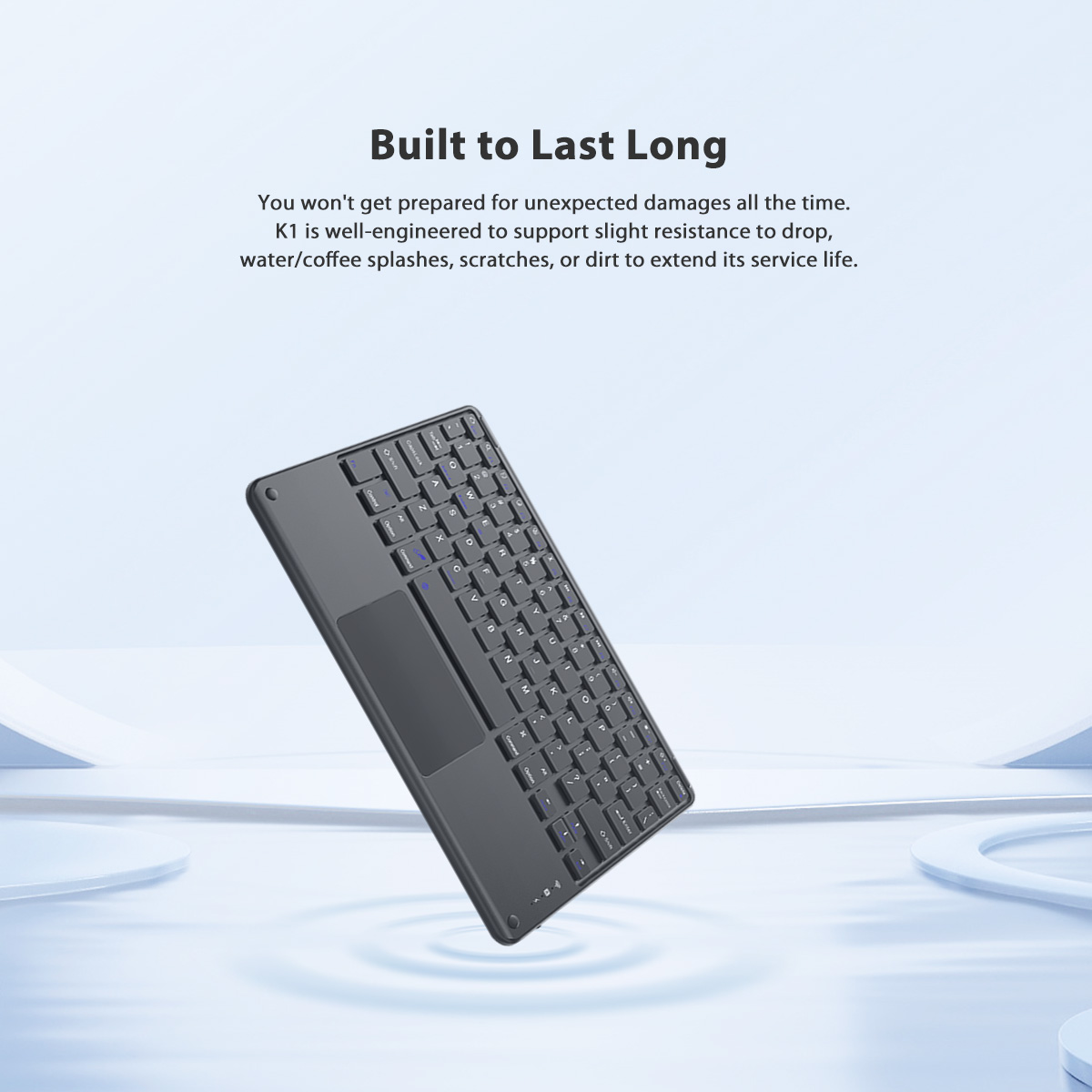 Eine dunkelgraue Tastatur mit Trackpad schwebt auf hellblauem Hintergrund.