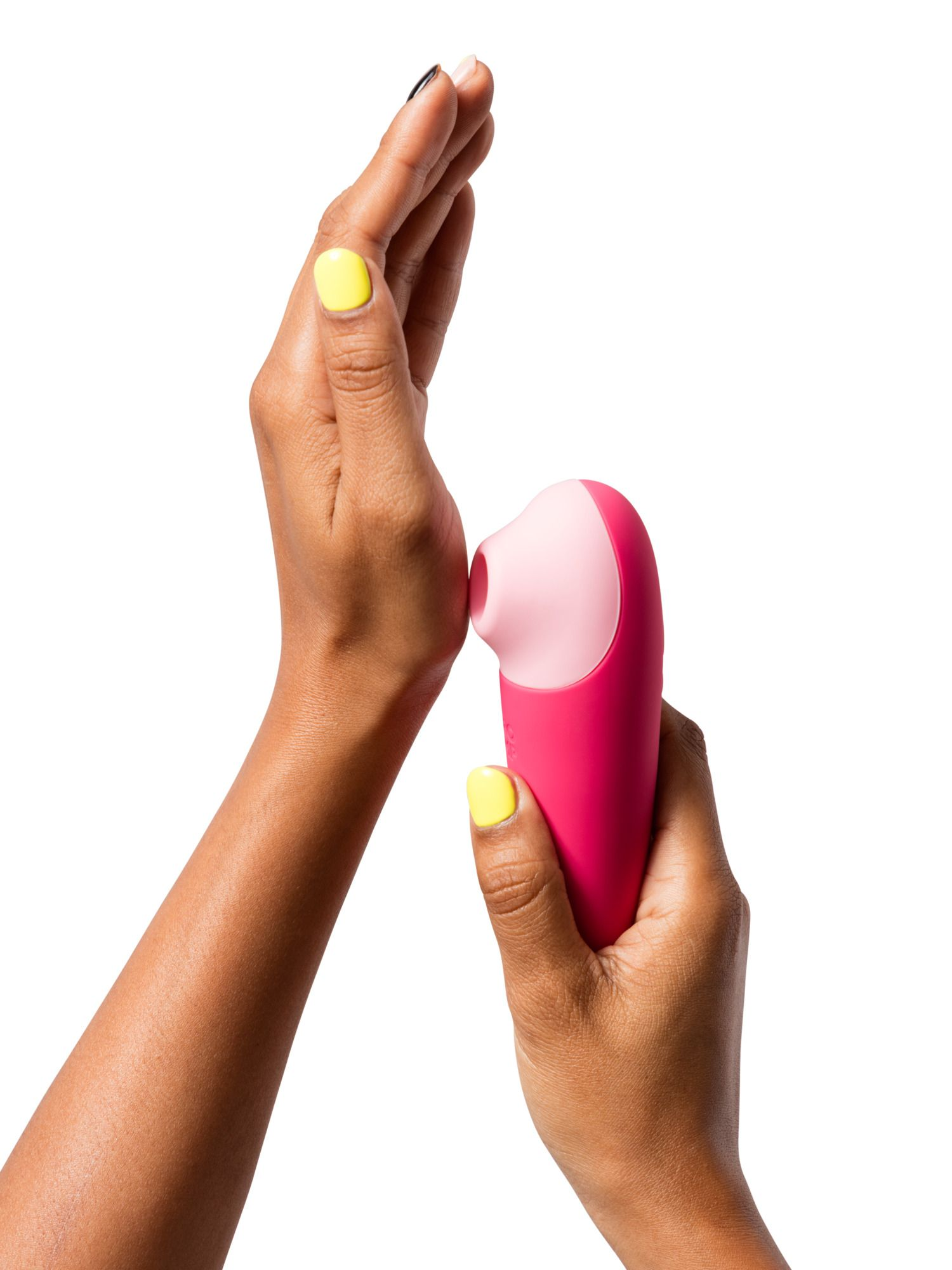 Manos sosteniendo un vibrador rosa y rosa claro sobre fondo blanco.
