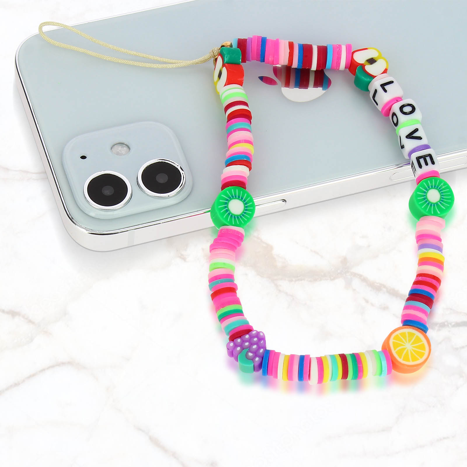 Un ciondolo colorato per telefono con perline, frutta e ciondoli 'LOVE' su un telefono.