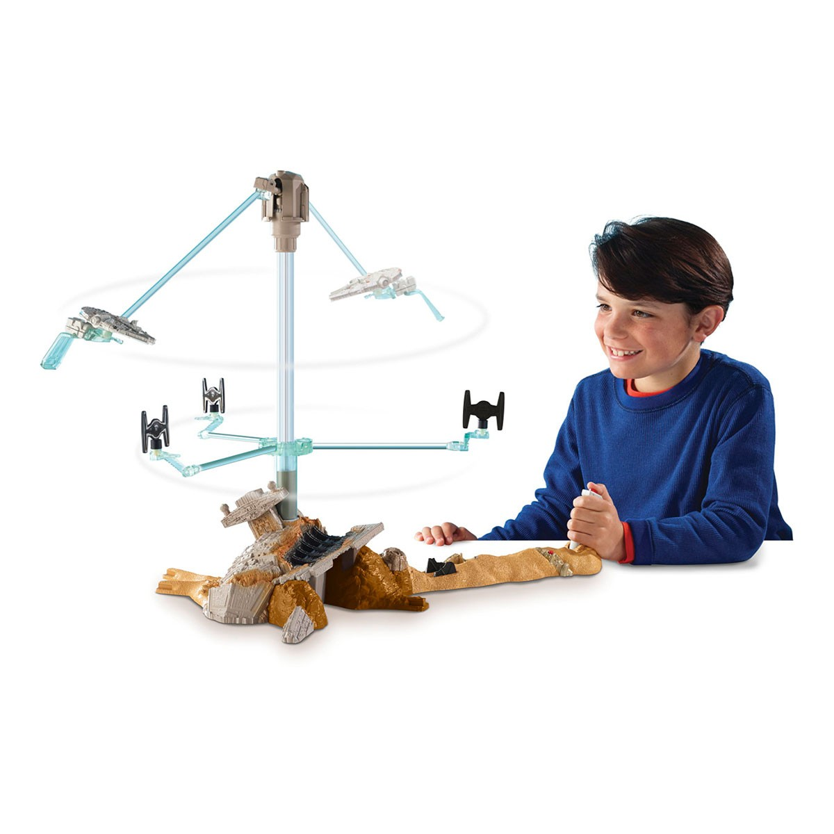 Ragazzo gioca con navi giocattolo di Star Wars che girano su un supporto con base in rovina.