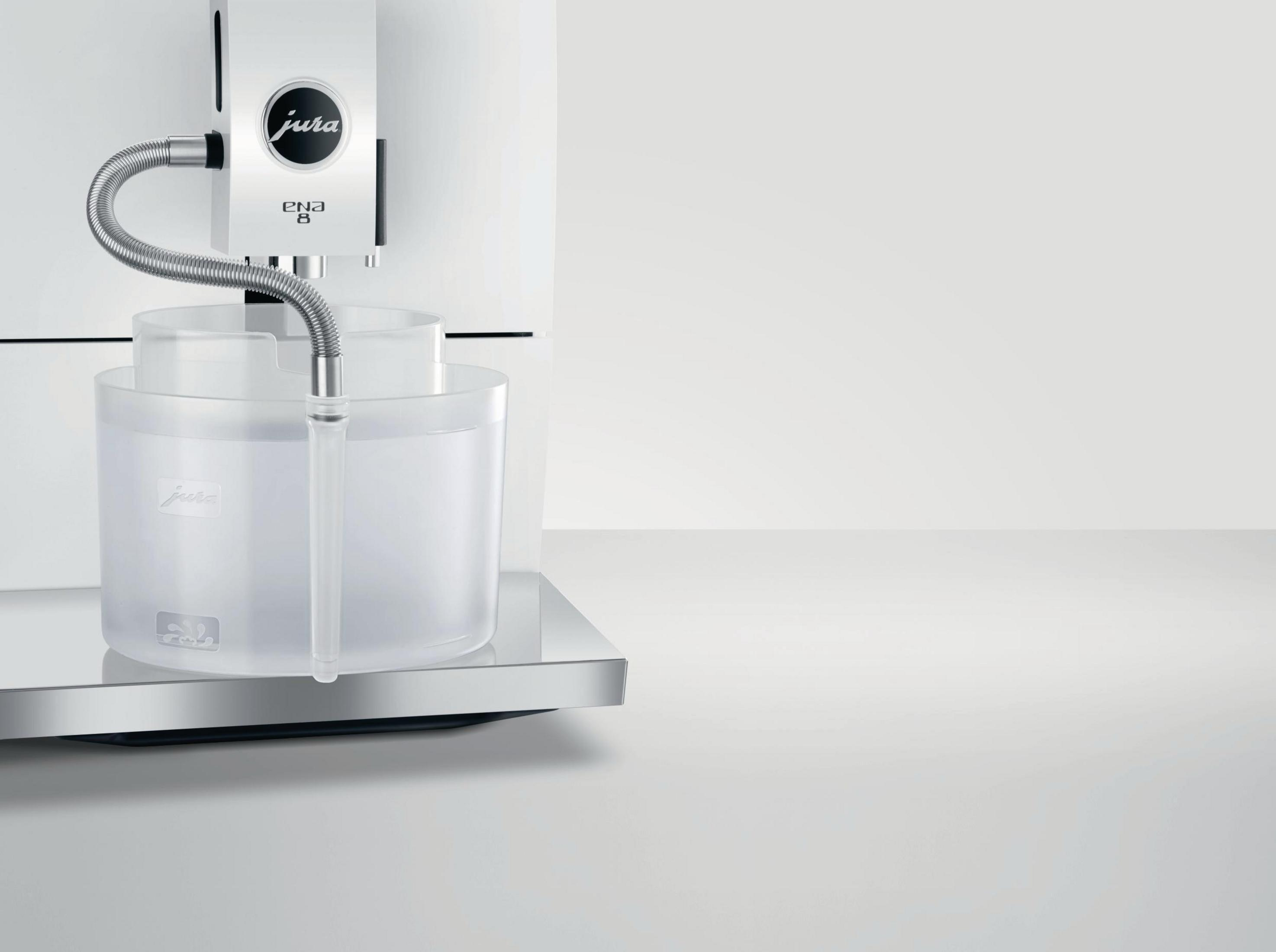 Eine Kaffeemaschine mit einem durchsichtigen Wassertank und einem Metallschlauch.