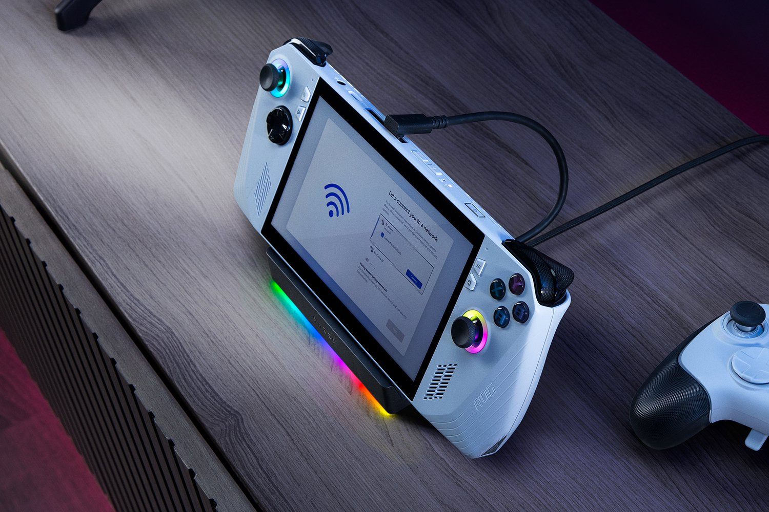 Un dispositivo di gioco portatile bianco con schermo di configurazione di rete è su una base con illuminazione RGB.