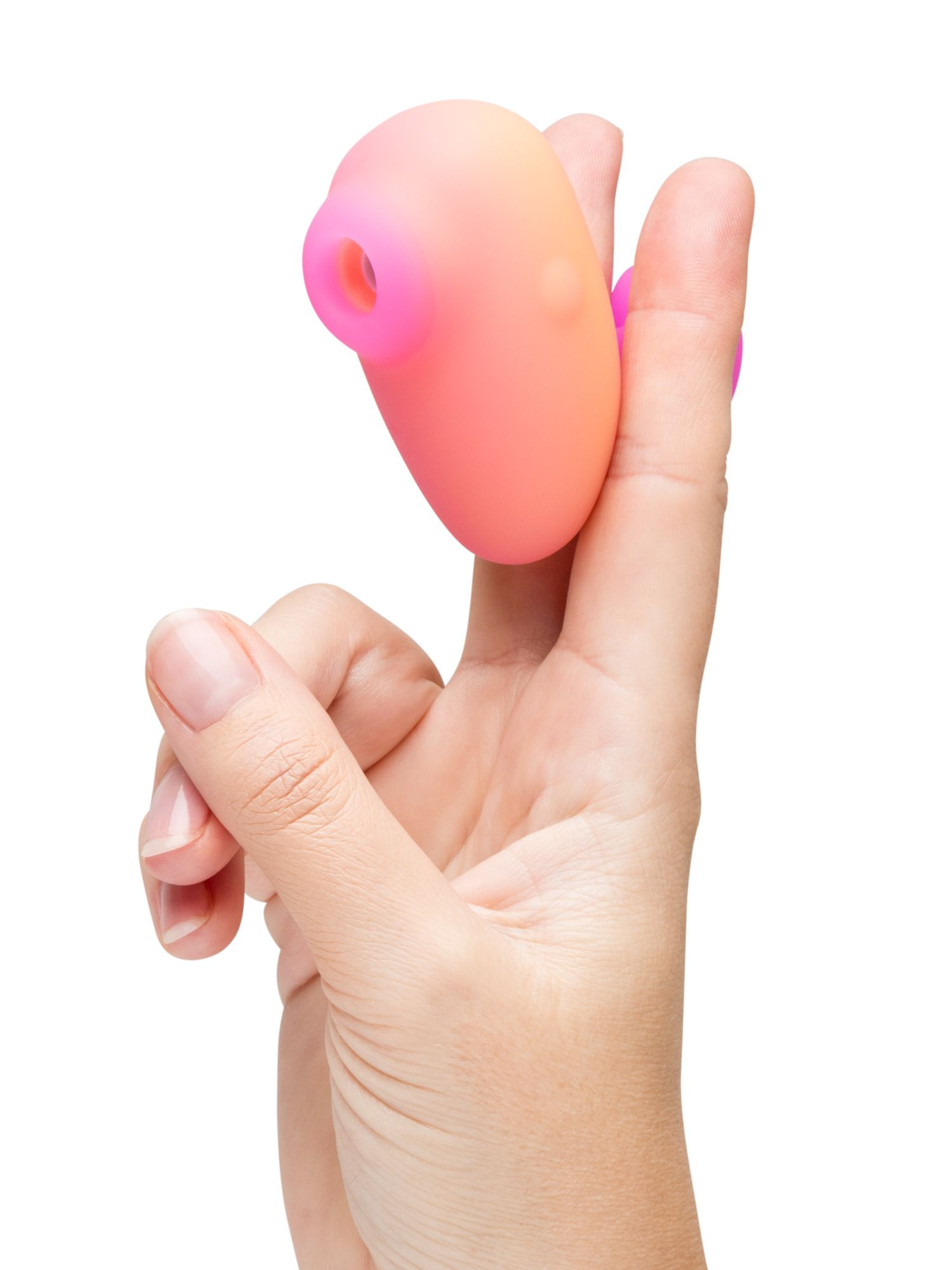 Una mano sostiene un objeto con forma de huevo rosa y naranja con un agujero en un extremo.