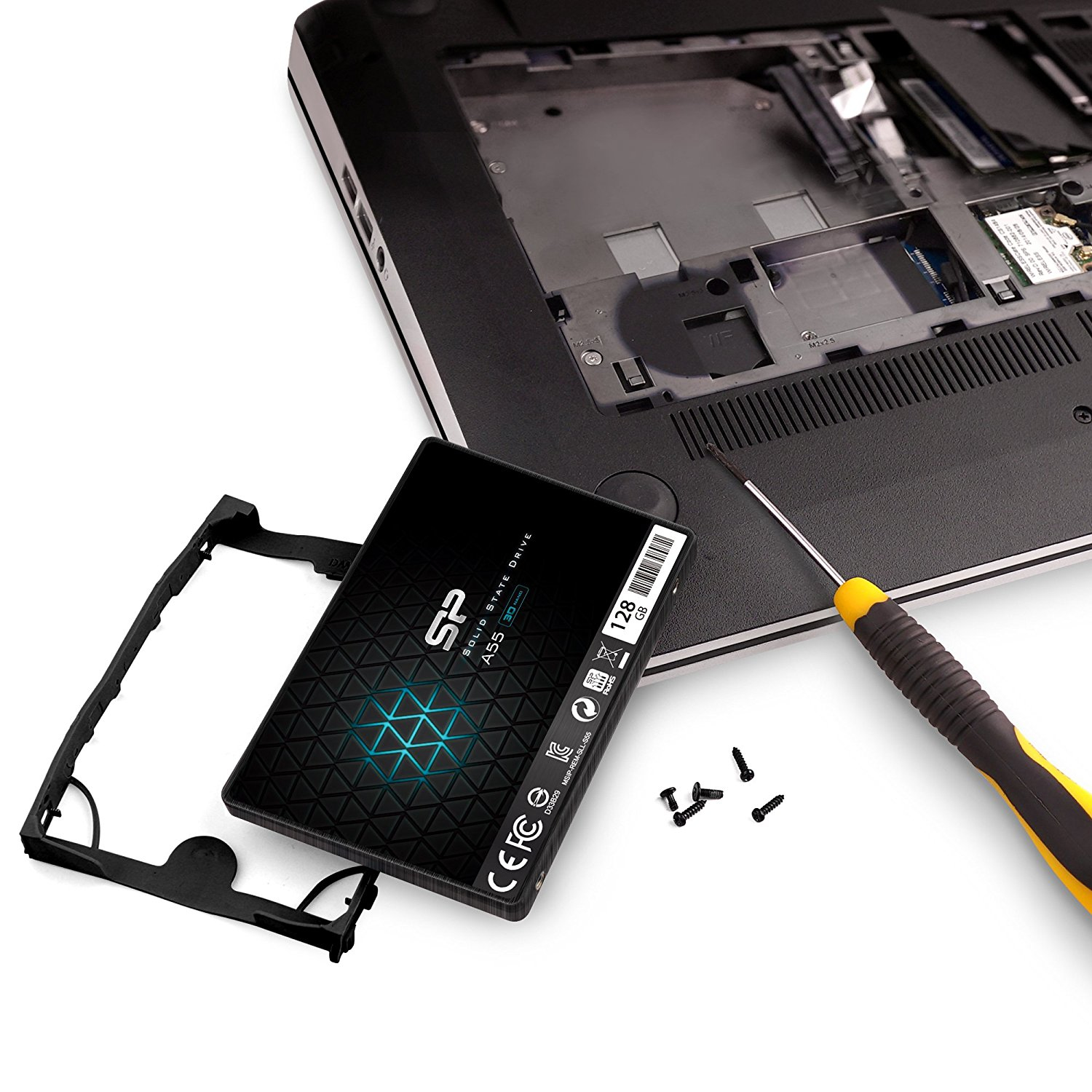 Laptop zdemontowany, pokazujący wewnętrzne komponenty i dysk SSD 128 GB ze śrubokrętem.