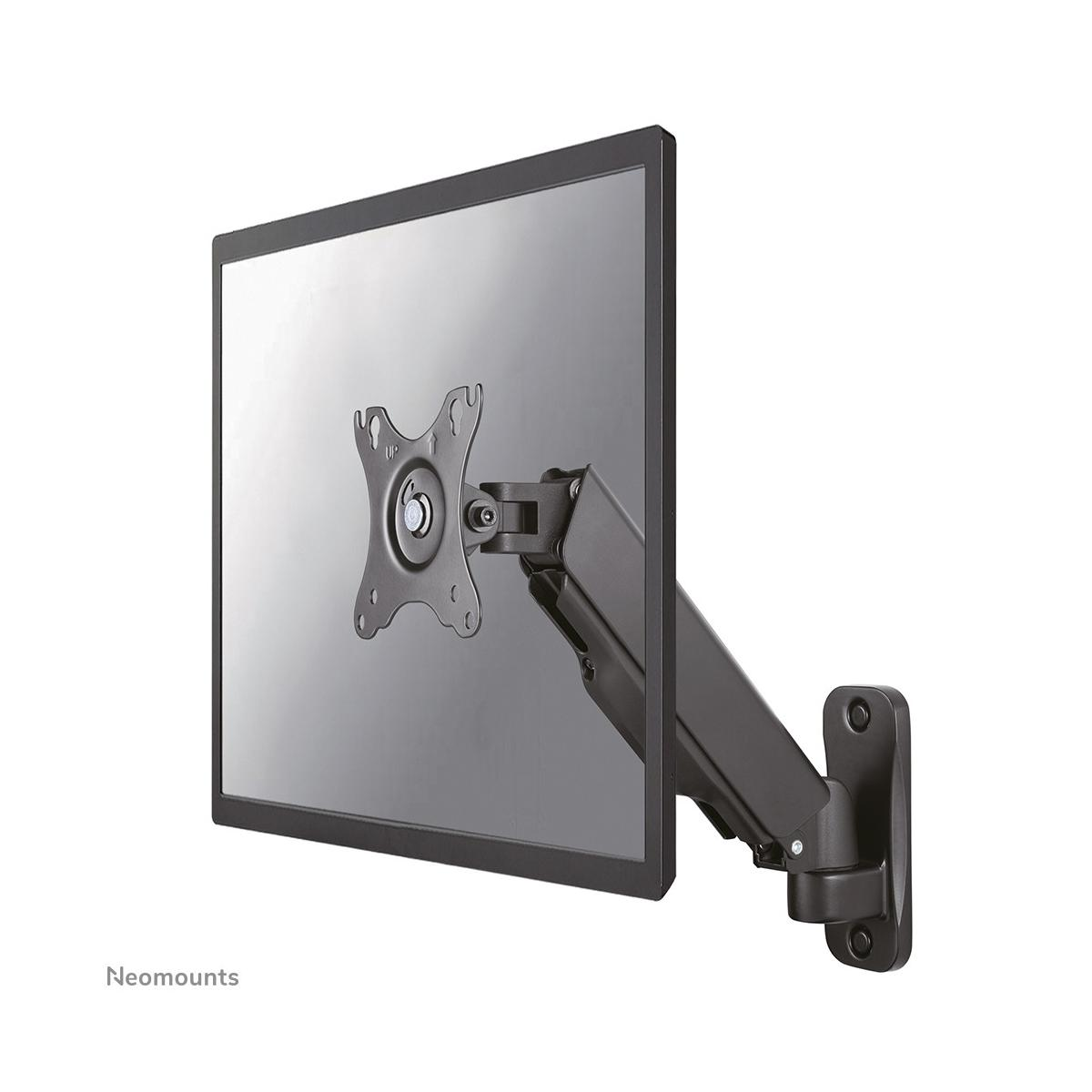 Een zwarte monitorarm wordt aan een monitor bevestigd, uitstekend uit een muurbevestiging.