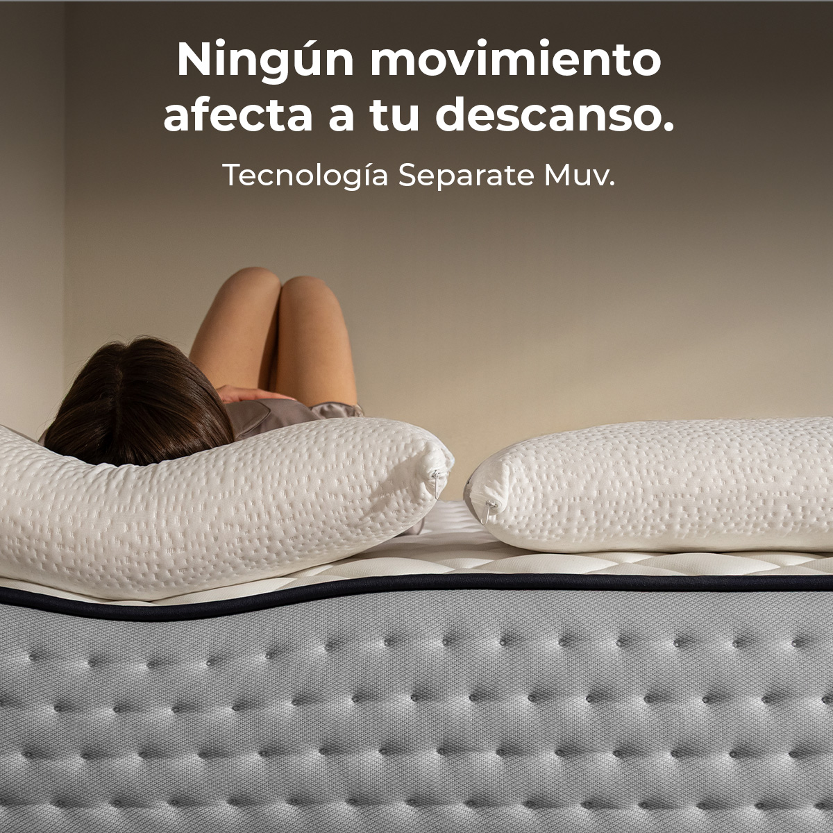 Una persona yace en un colchón con dos almohadas. Texto: "Ningún movimiento afecta tu descanso."