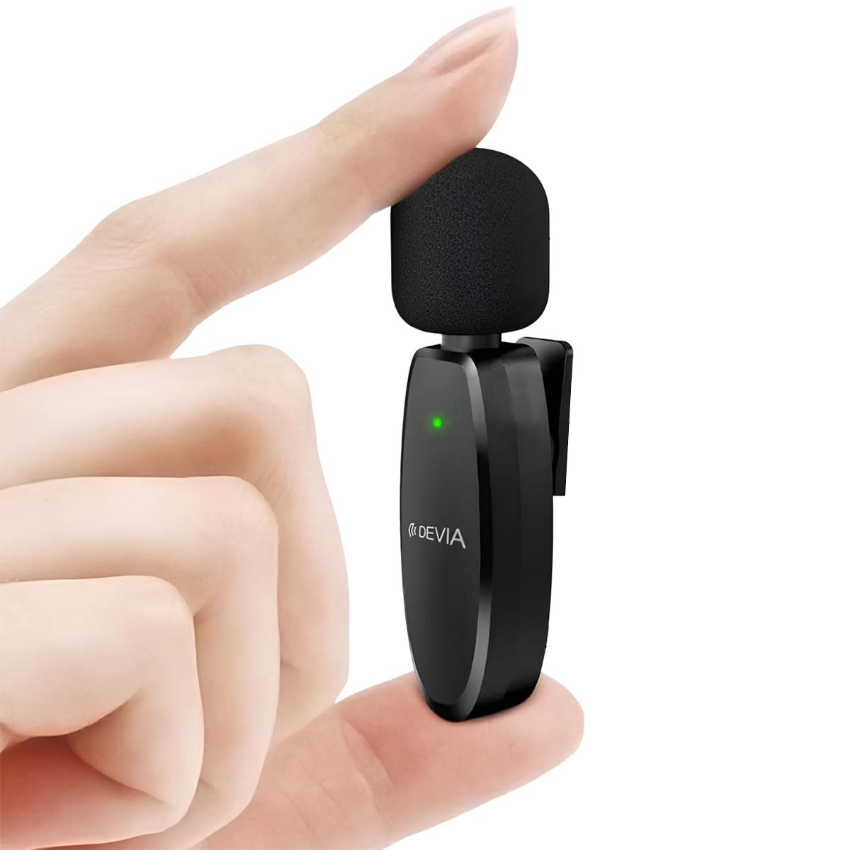 Un microfono wireless nero con luce verde è tenuto da dita su sfondo bianco.