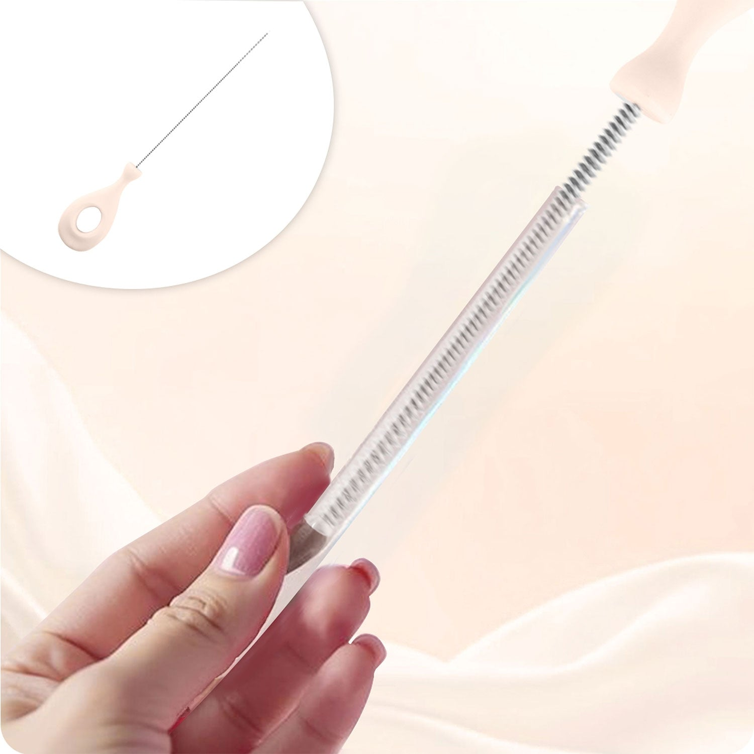 Una mano sostiene un cepillo de limpieza delgado y flexible con mango rosa claro y cerdas metálicas.