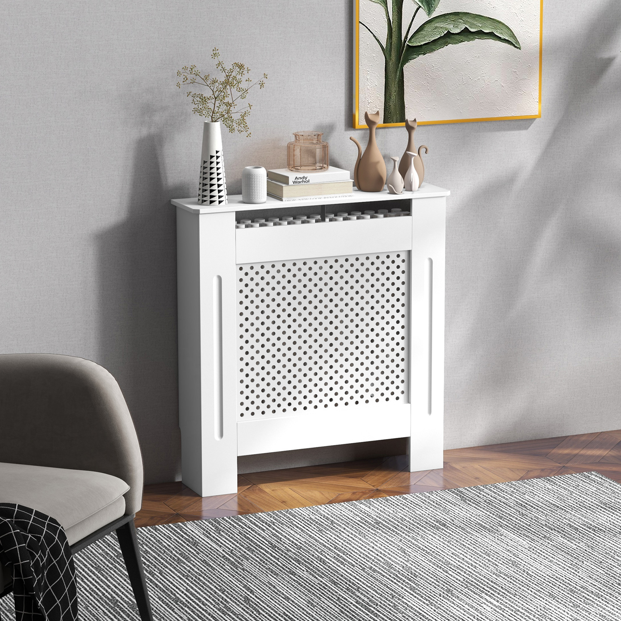 Copritermosifone bianco con vasi decorativi, libri e statuette di gatti sopra. Sedia grigia nelle vicinanze.