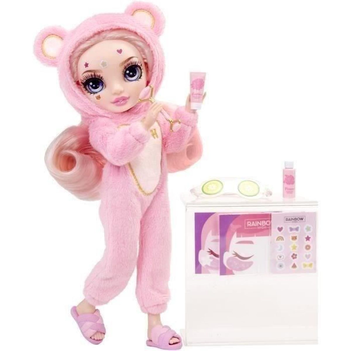 Una bambola in pigiama a orso rosa tiene un rullo di giada e crema. Un mini frigo ha articoli per la cura della pelle.