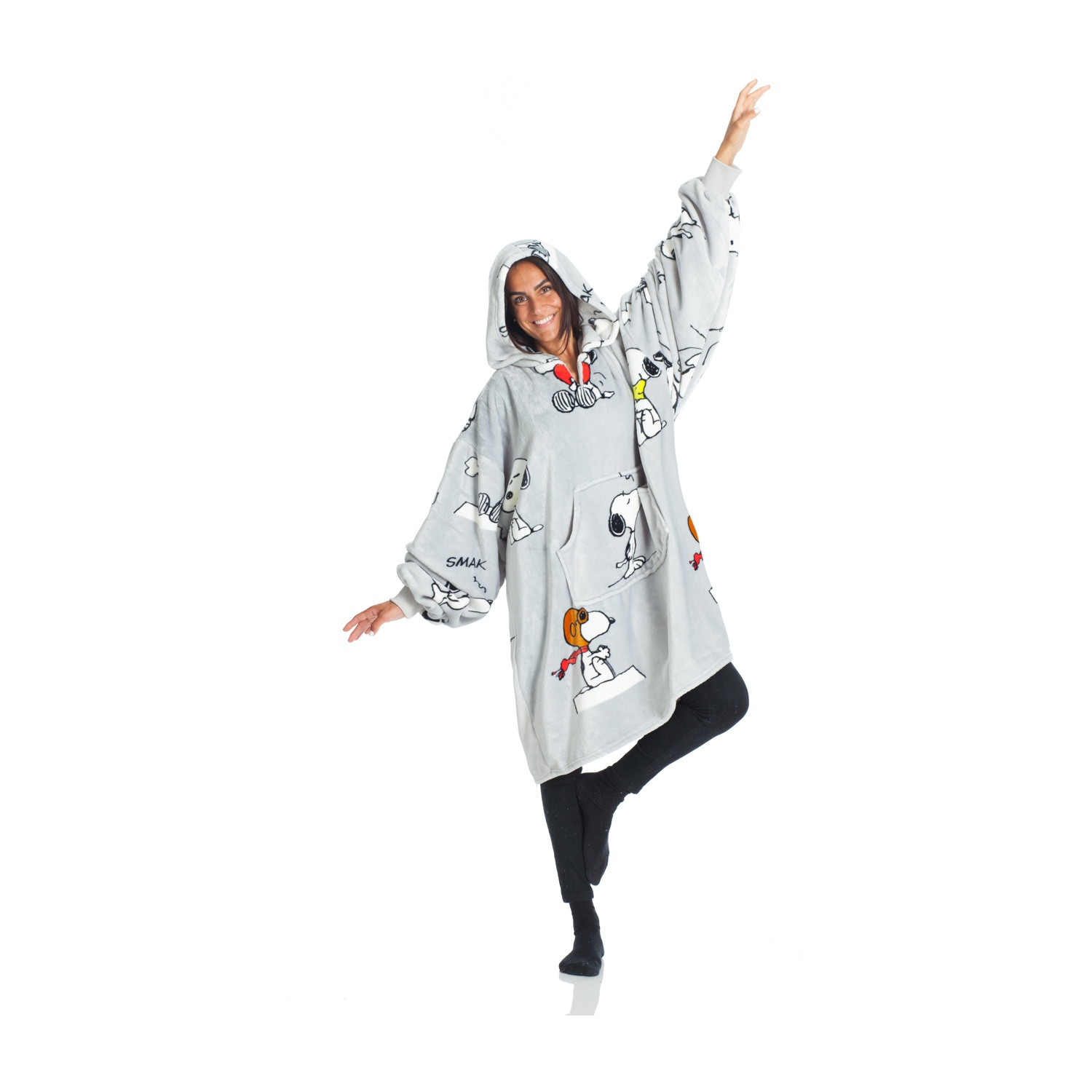 Donna in felpa grigia Snoopy, leggings neri e calzini neri, in posa con le braccia tese.