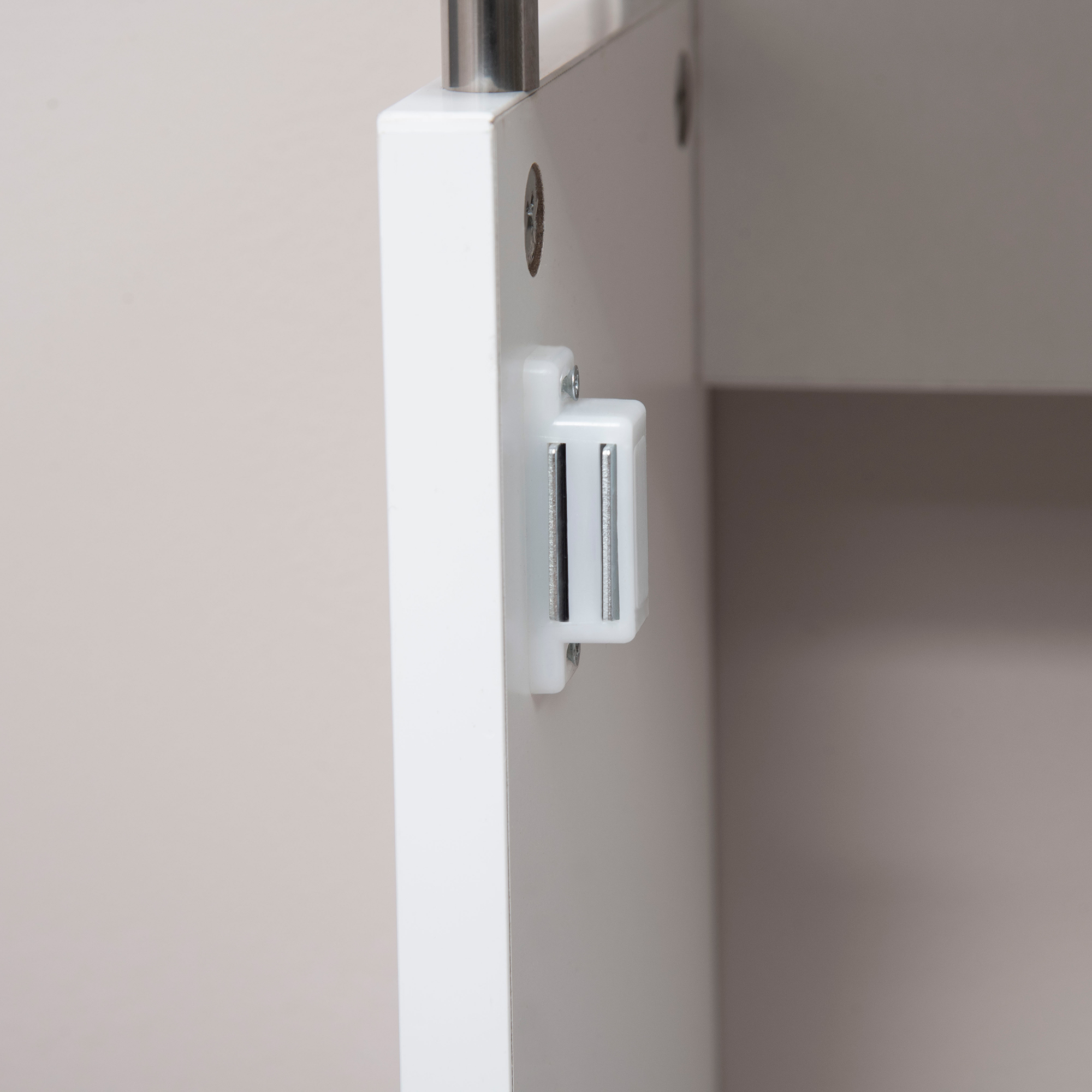Porta dell'armadio bianca con chiusura magnetica e viti metalliche su sfondo neutro.