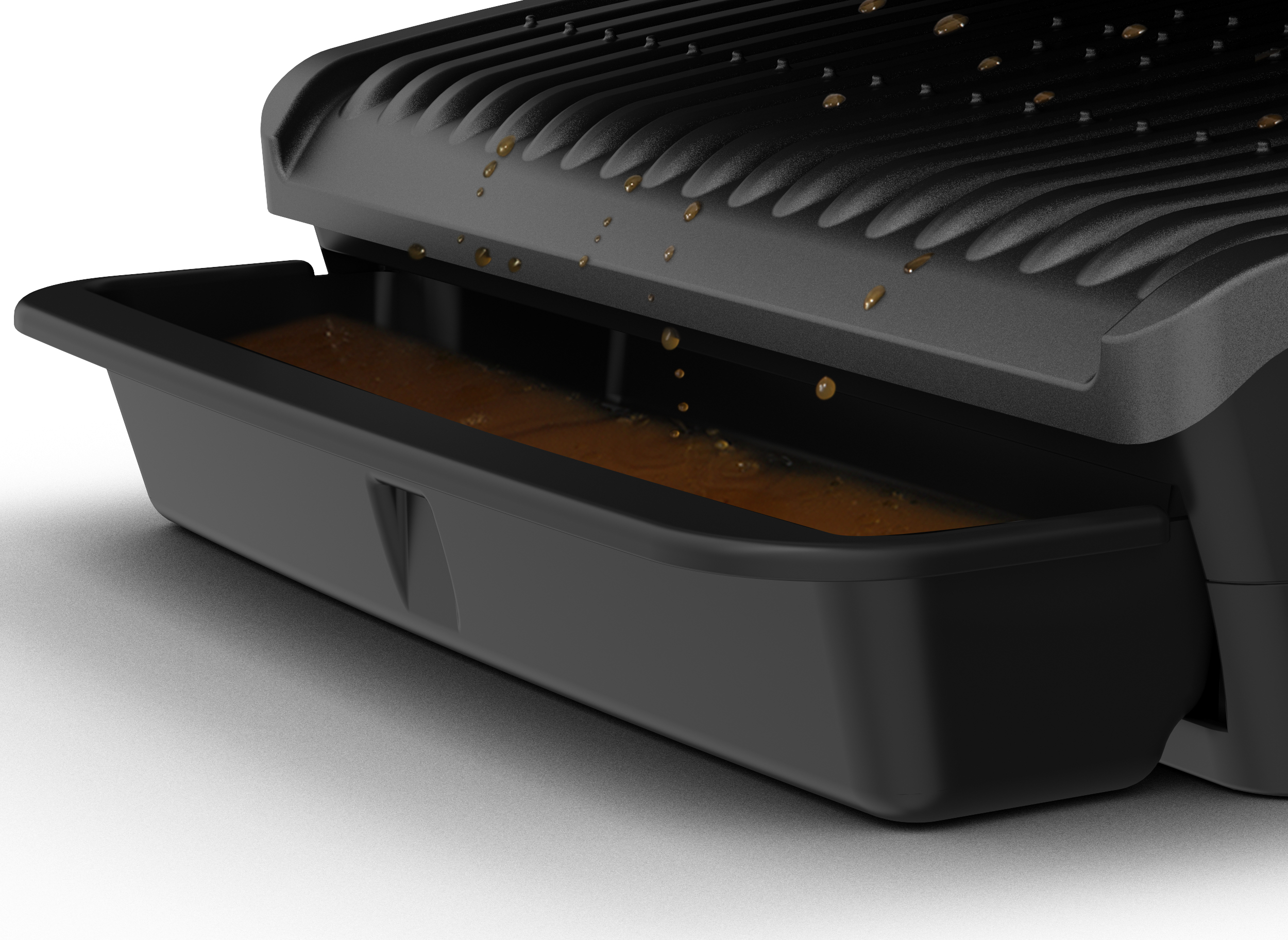 Des gouttes tombent d'une plaque de grill dans un bac de récupération noir avec un liquide brun.