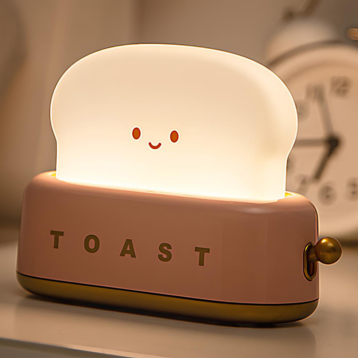 Ein niedliches toastförmiges Nachtlicht mit lächelndem Gesicht steht auf einer Oberfläche.