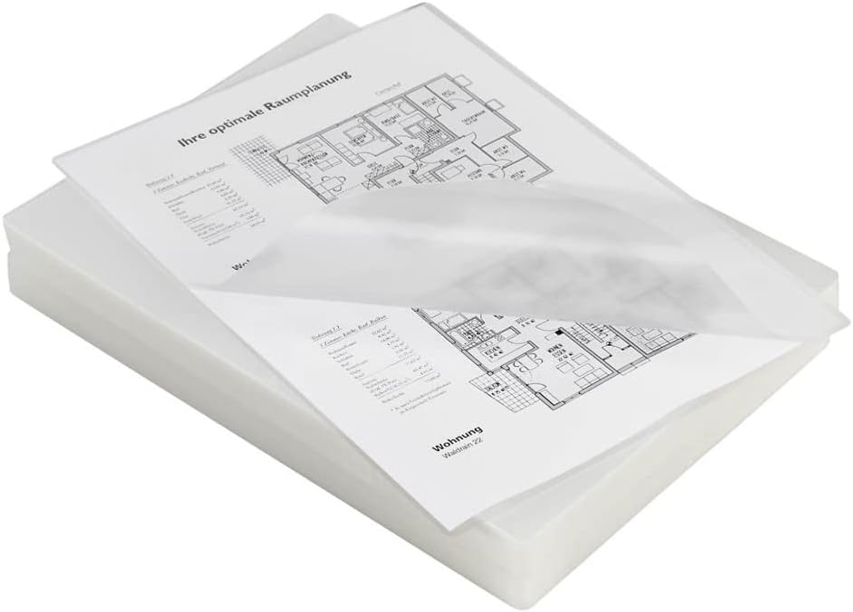 Stos białych papierów z planami architektonicznymi i tekstem, częściowo przykryty przezroczystą folią.