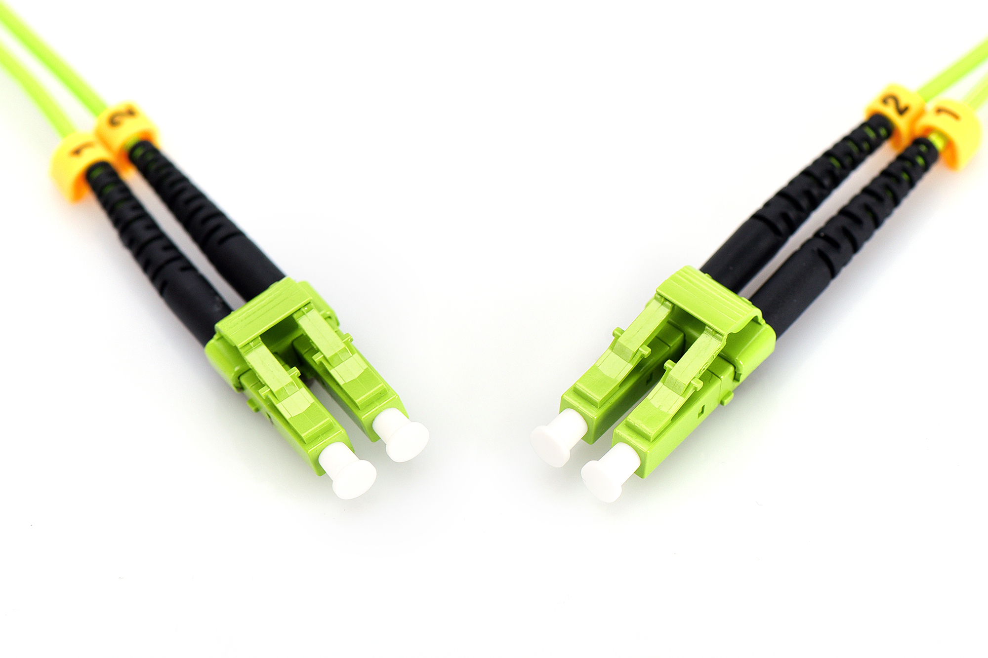 Due cavi in fibra ottica verdi con connettori neri e tappi bianchi su sfondo bianco.