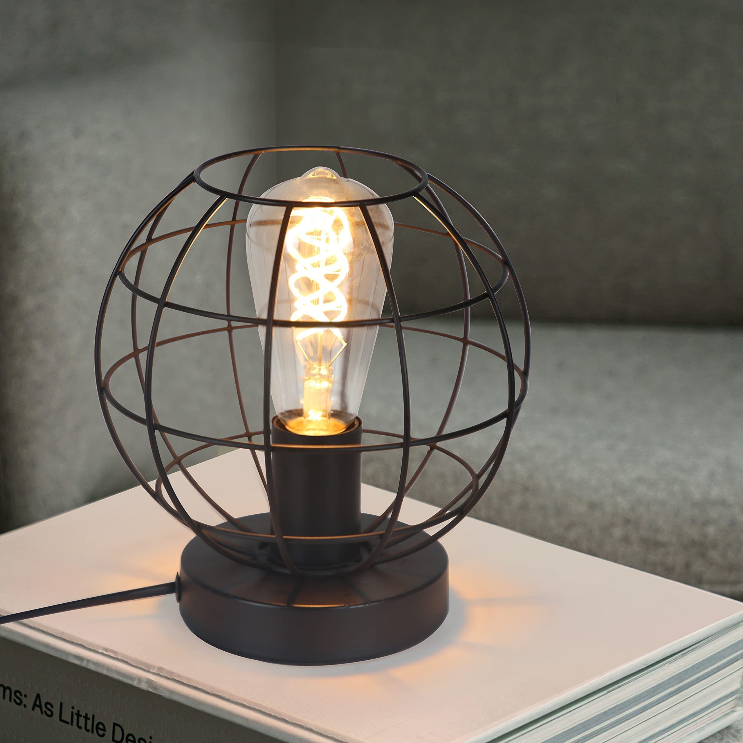 Una lampada da tavolo a gabbia in metallo nero con lampadina a filamento su libri.