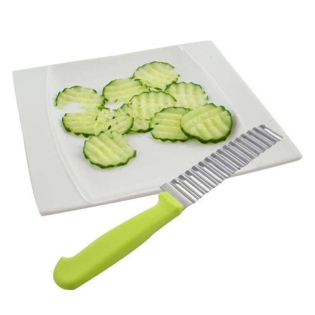 Un cuchillo rebanador de corte ondulado con mango verde yace junto a rodajas de pepino en un plato blanco.