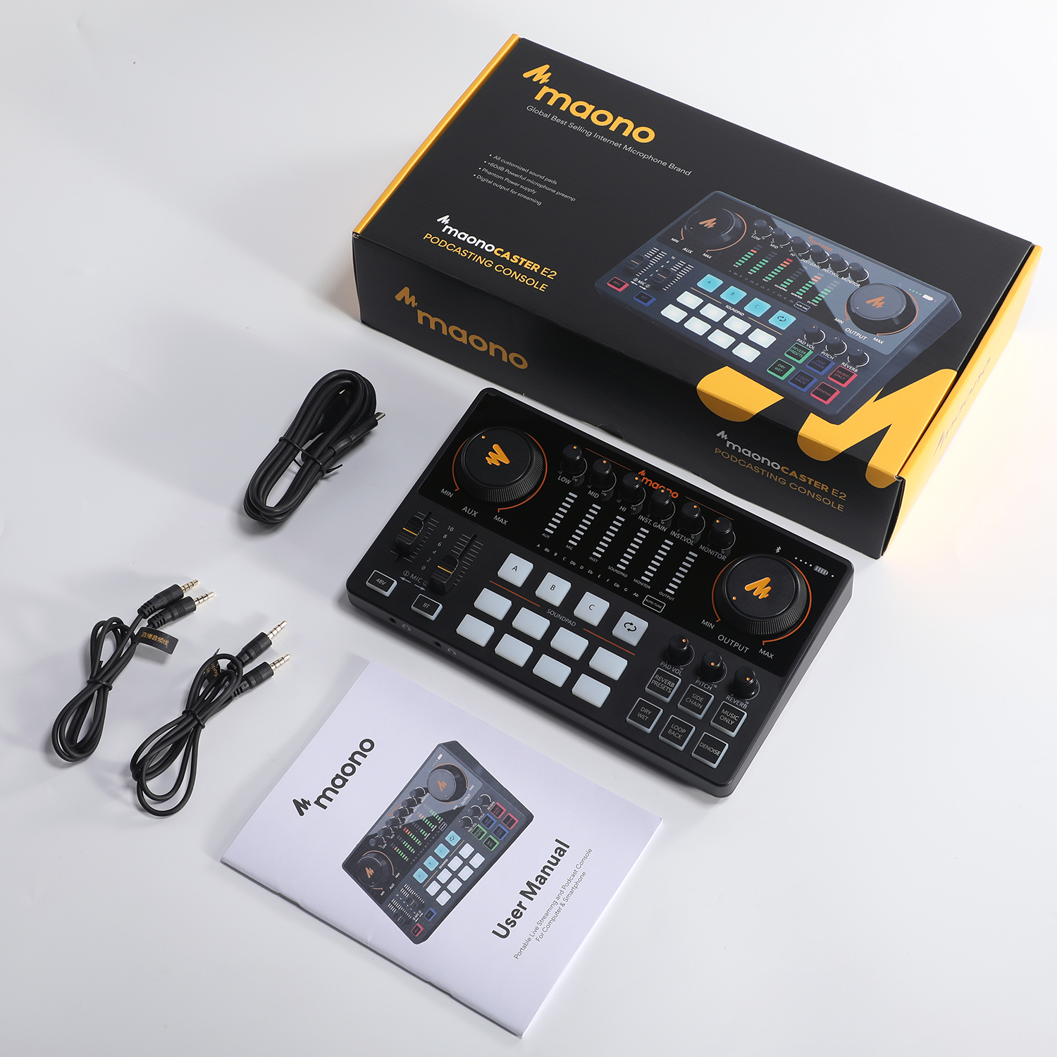Maonocaster E2 mit Kabeln und Handbuch auf weißem Hintergrund.