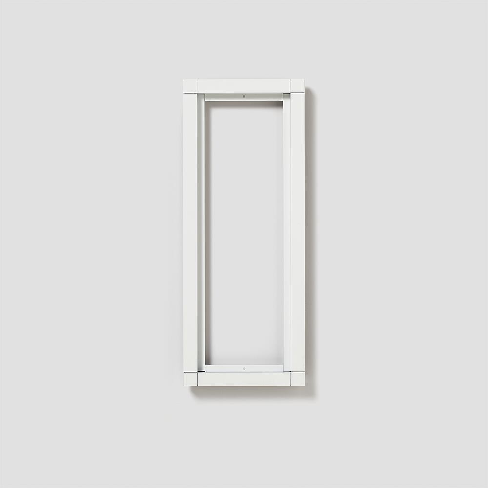 Una cornice rettangolare bianca su un muro grigio semplice. La cornice è sottile e moderna.