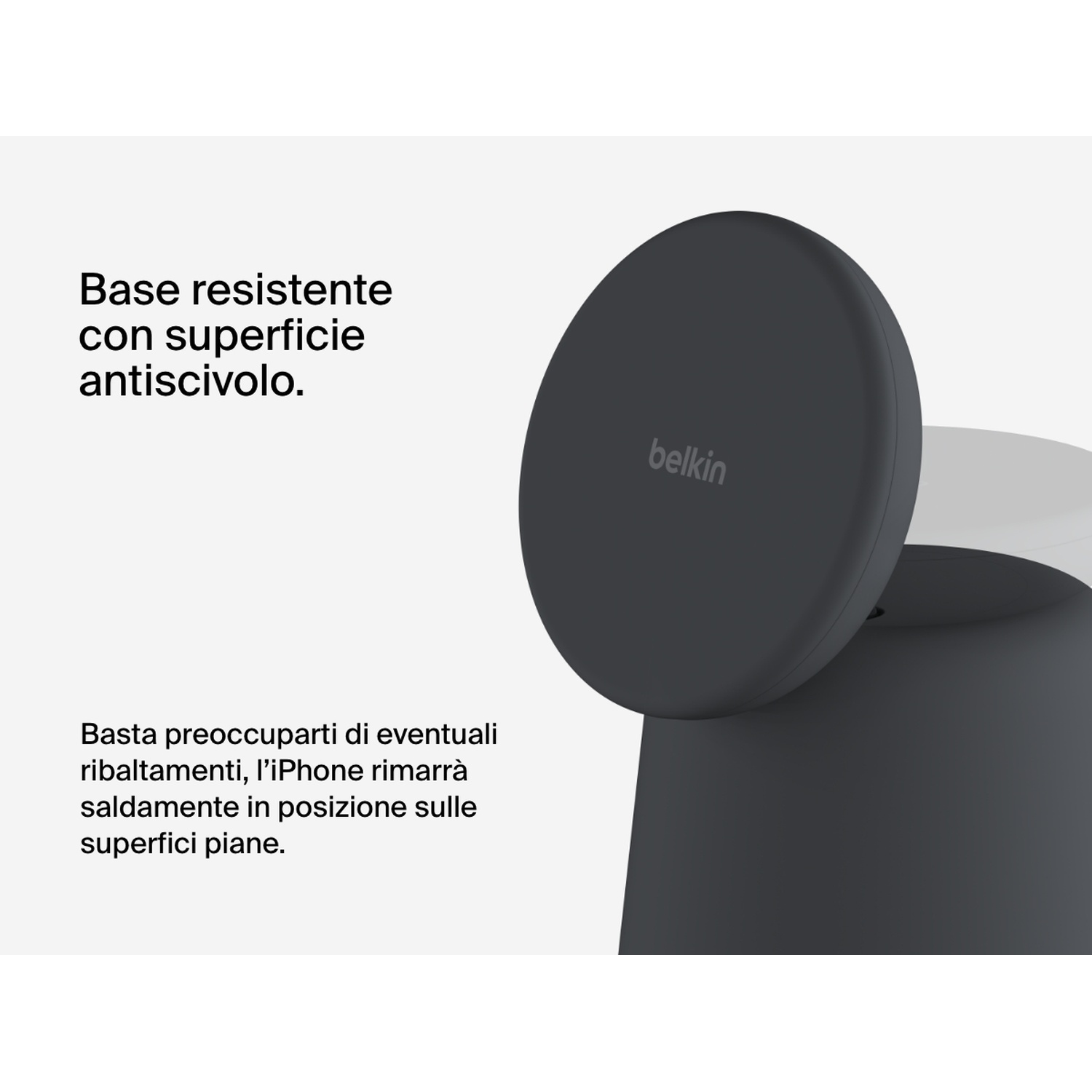 Un supporto rotondo scuro con logo Belkin su superficie bianca.