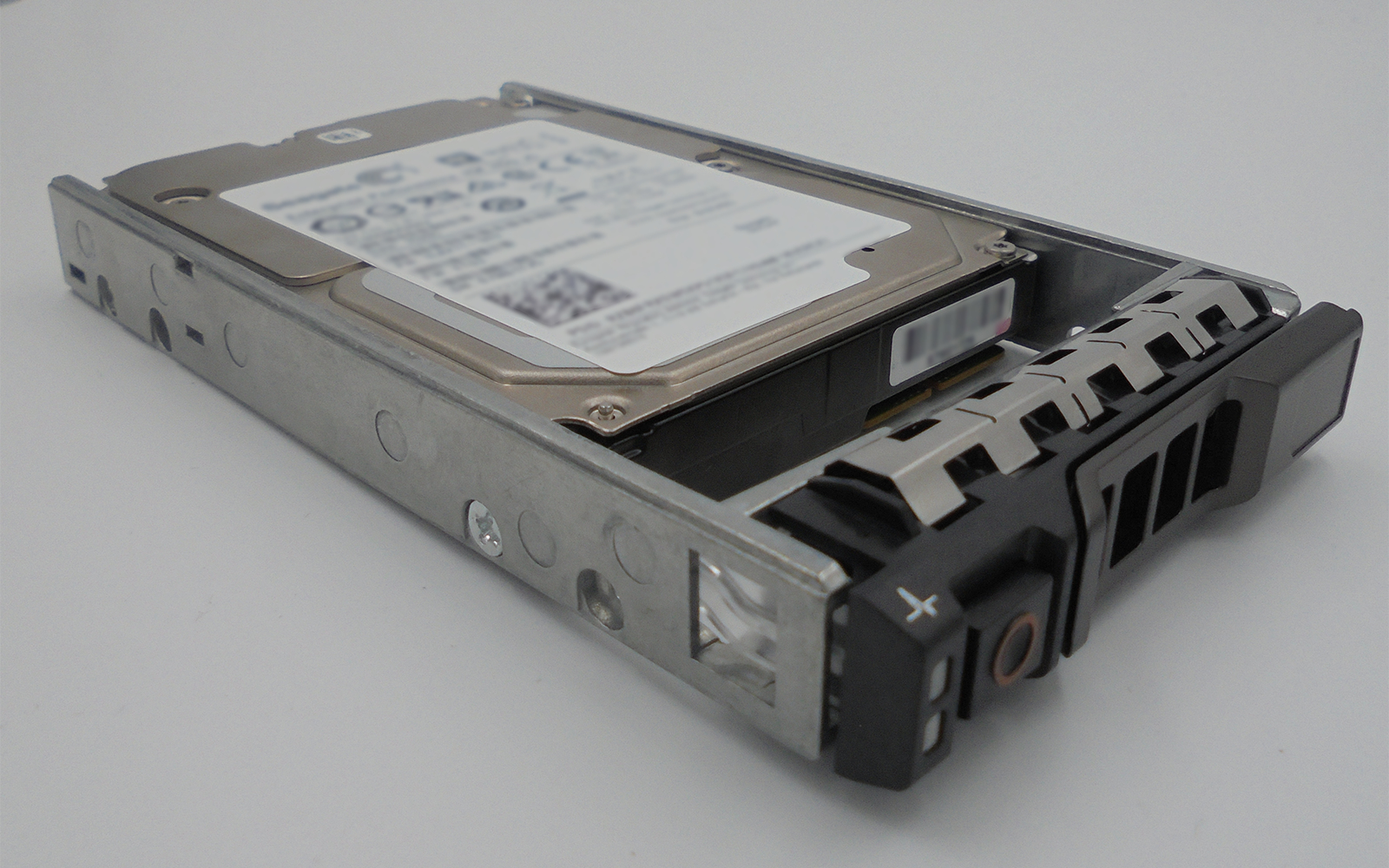 Un hard disk metallico con connettore nero ed etichetta bianca sopra.