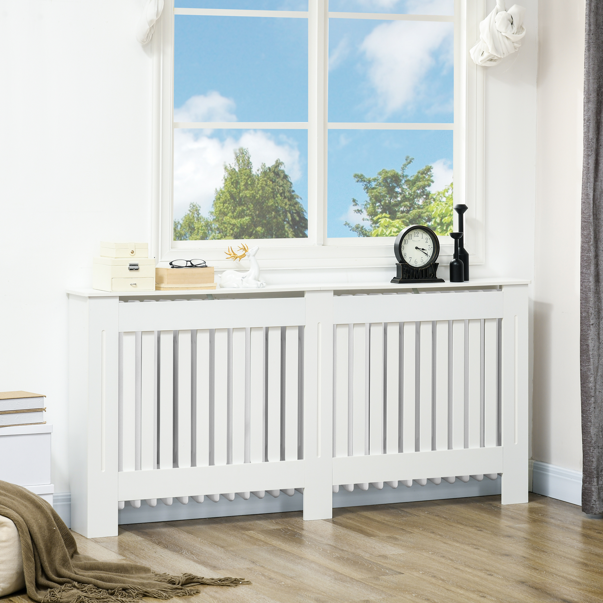 Una copertura per radiatore bianca con ornamenti e una finestra sullo sfondo.