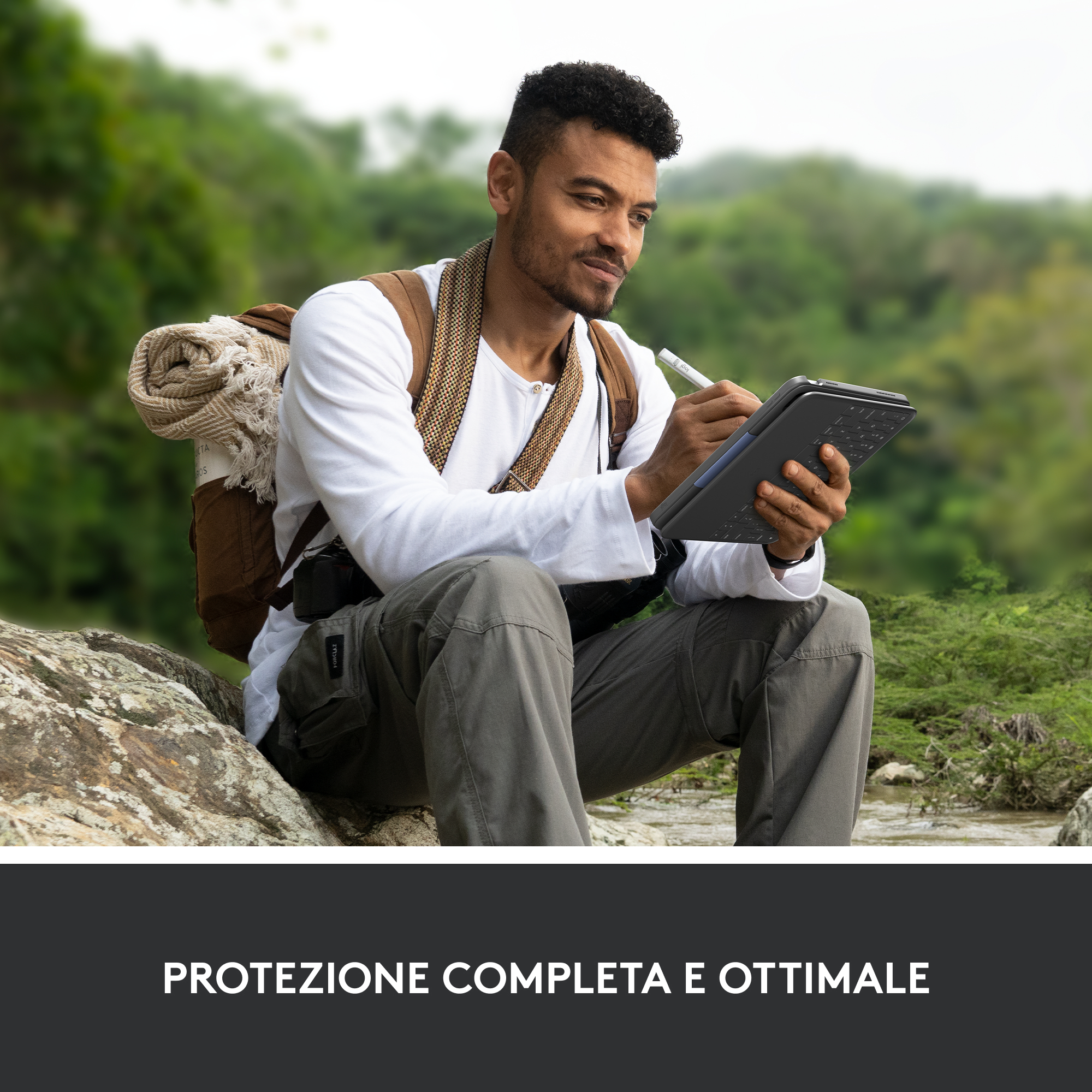 Un uomo seduto all'aperto usa un tablet con uno stilo.