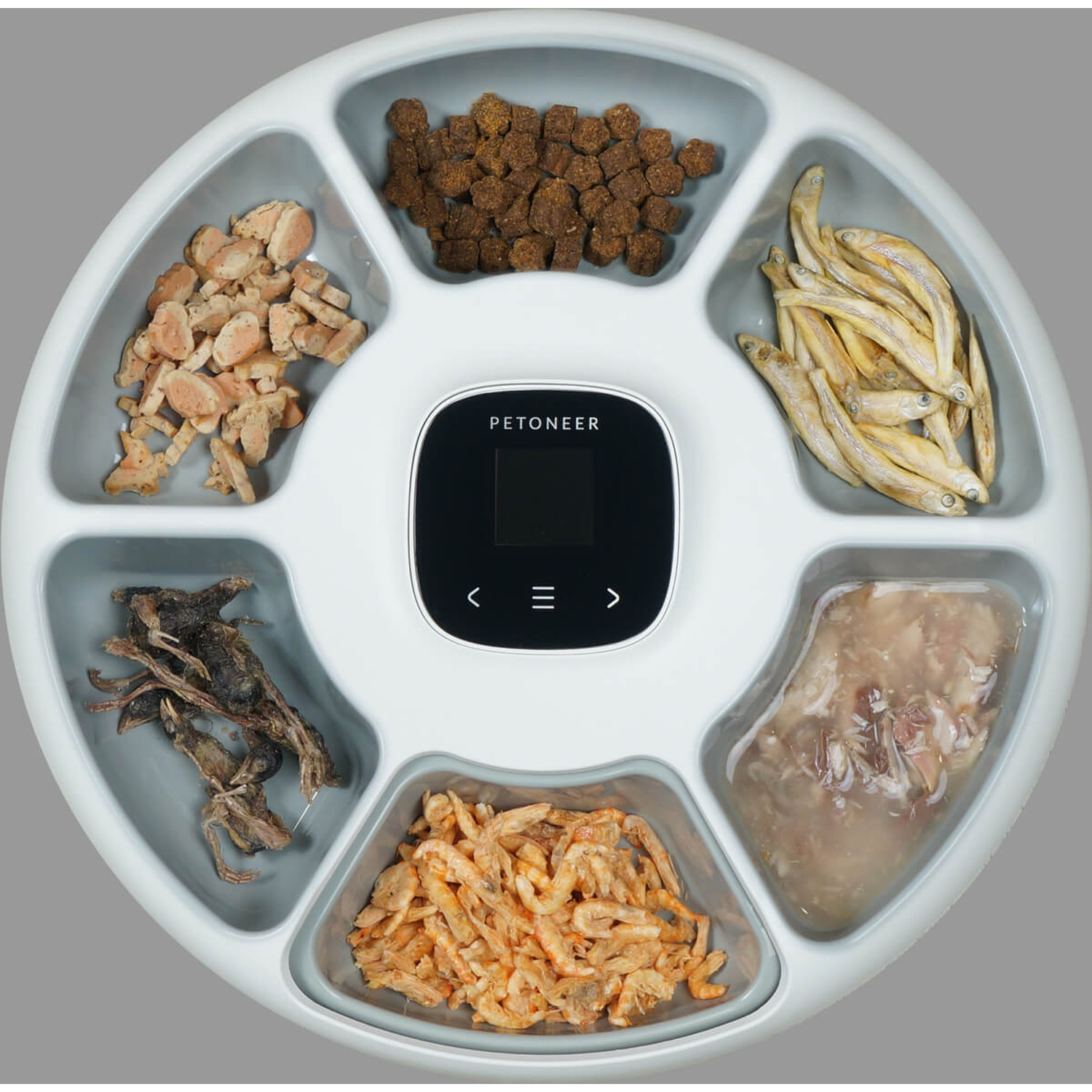 Biały automatyczny karmnik dla zwierząt z sześcioma przegródkami wypełnionymi różnymi pokarmami.