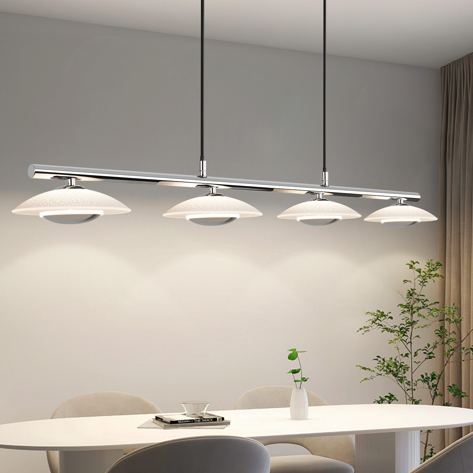 Un comedor moderno con mesa ovalada blanca, sillas y lámpara colgante cromada.