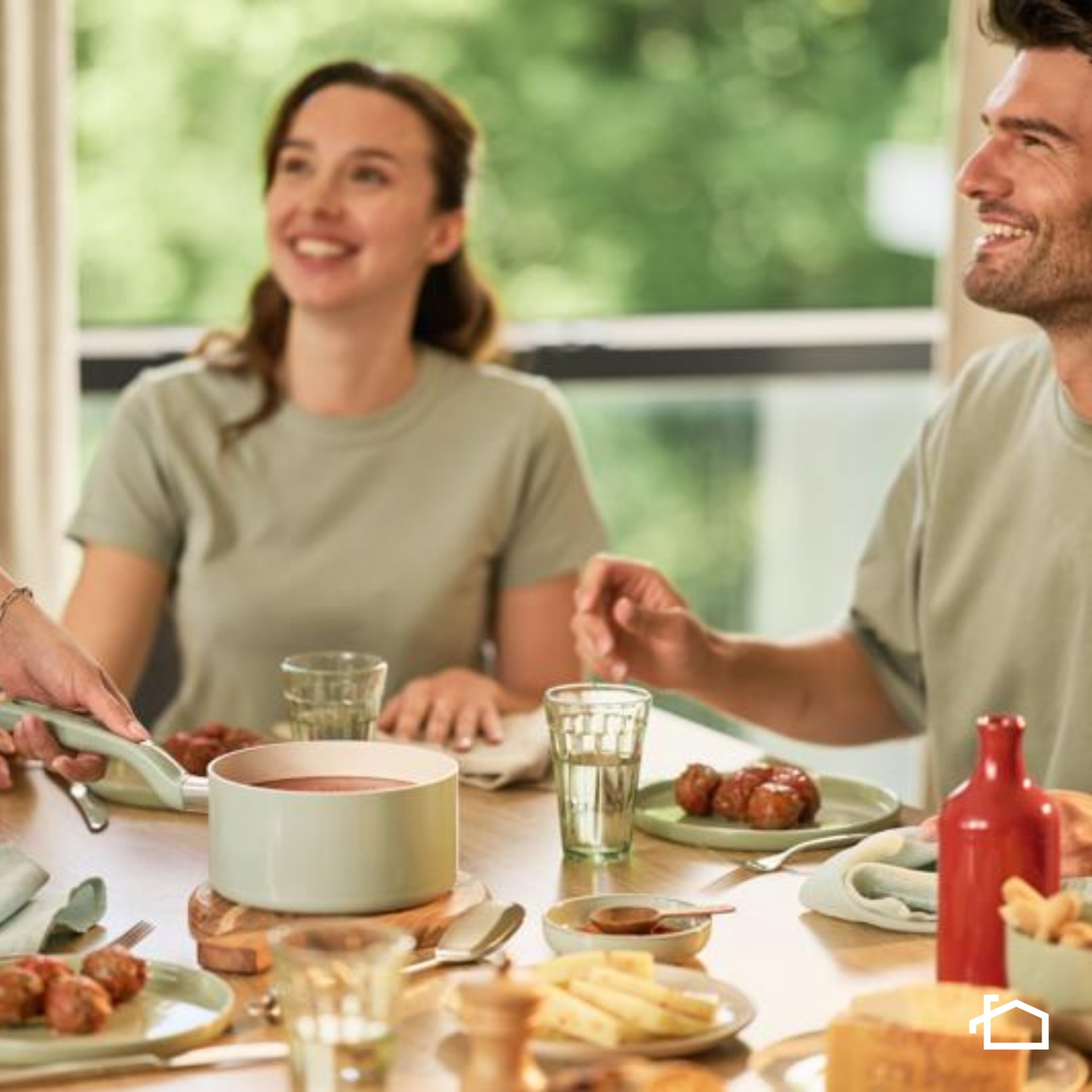 Personas disfrutan de una comida en una mesa, con comida y bebidas.