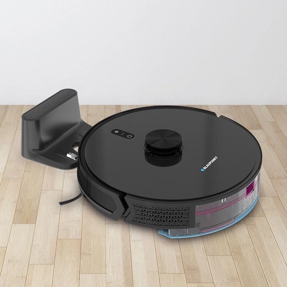 Siyah bir Blaupunkt robot süpürge, ahşap zemindeki şarj istasyonuna yanaşmış durumda.