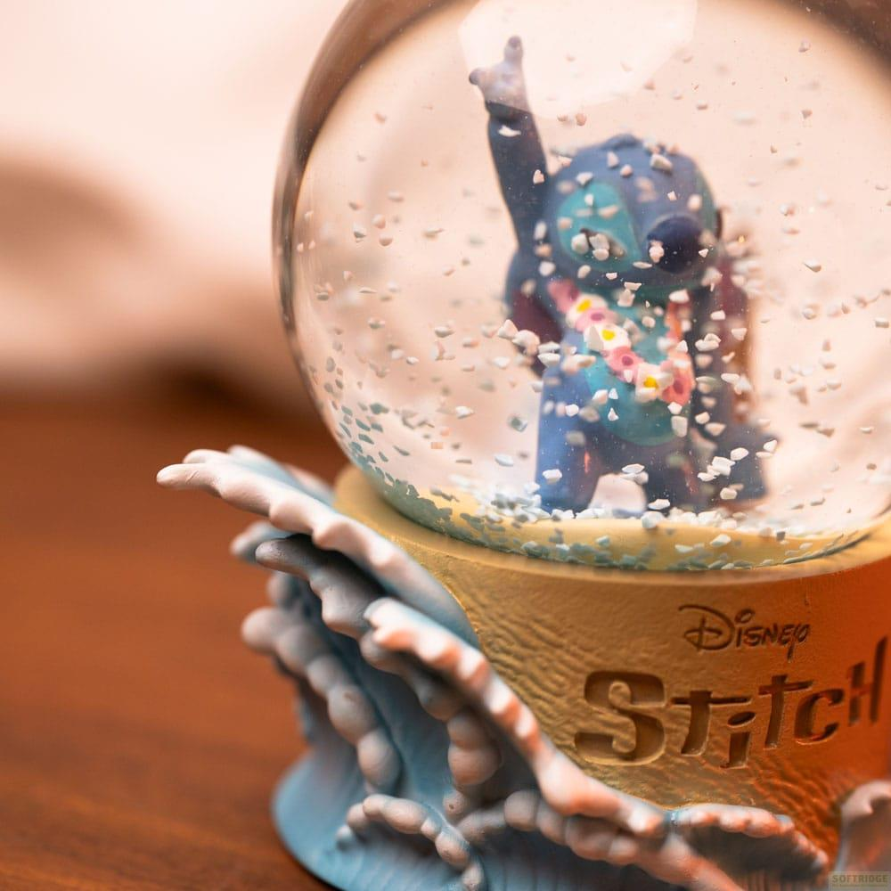 Stitch-Schneekugel mit Figur, die Rock'n'Roll-Geste macht, auf blauem Sockel.