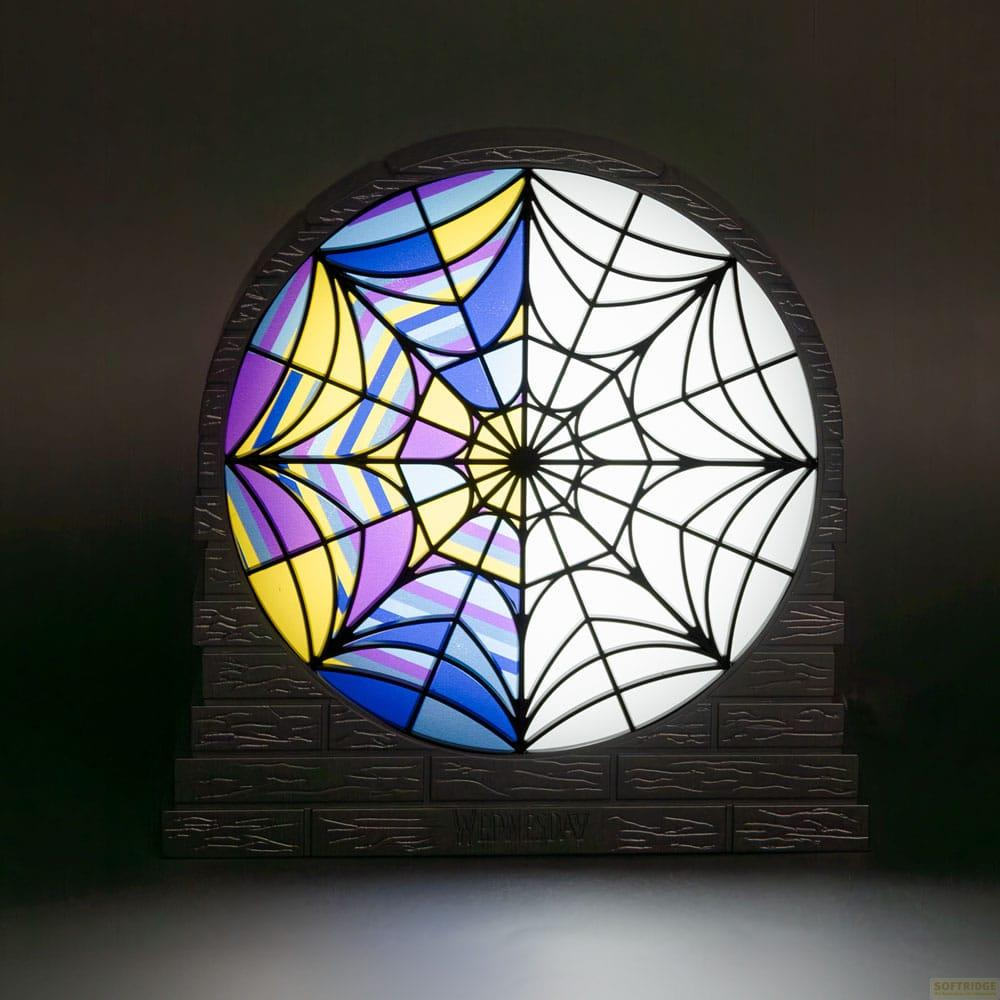 Una ventana redonda de vidrieras con diseño de telaraña. Mitad colorida, mitad blanca.