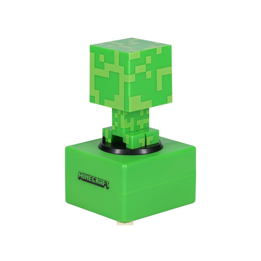 Zielona figurka Minecraft Creeper stoi na dopasowanej zielonej podstawie z logo Minecraft.