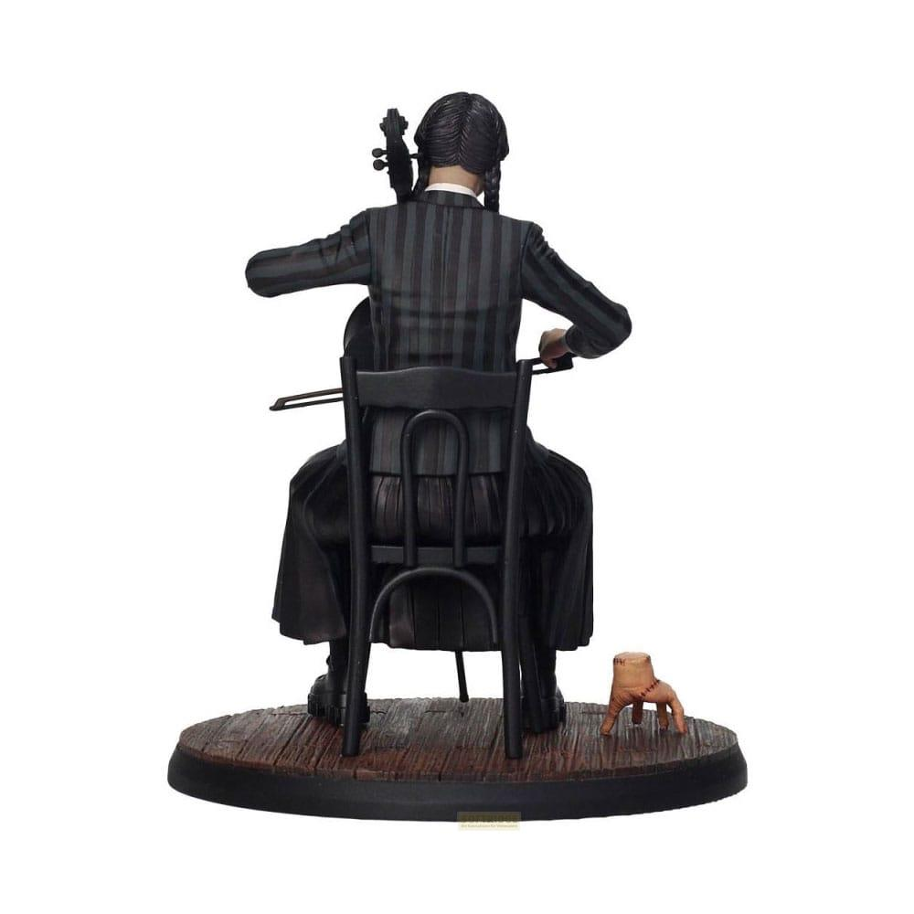 Una figura sentada tocando el violonchelo en una silla, con una mano cortada al lado.