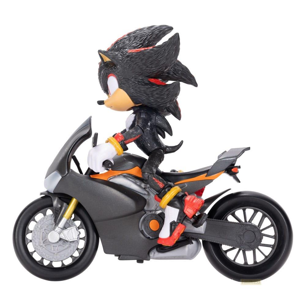 Figura de Shadow the Hedgehog monta una motocicleta gris y naranja, vista de lado.