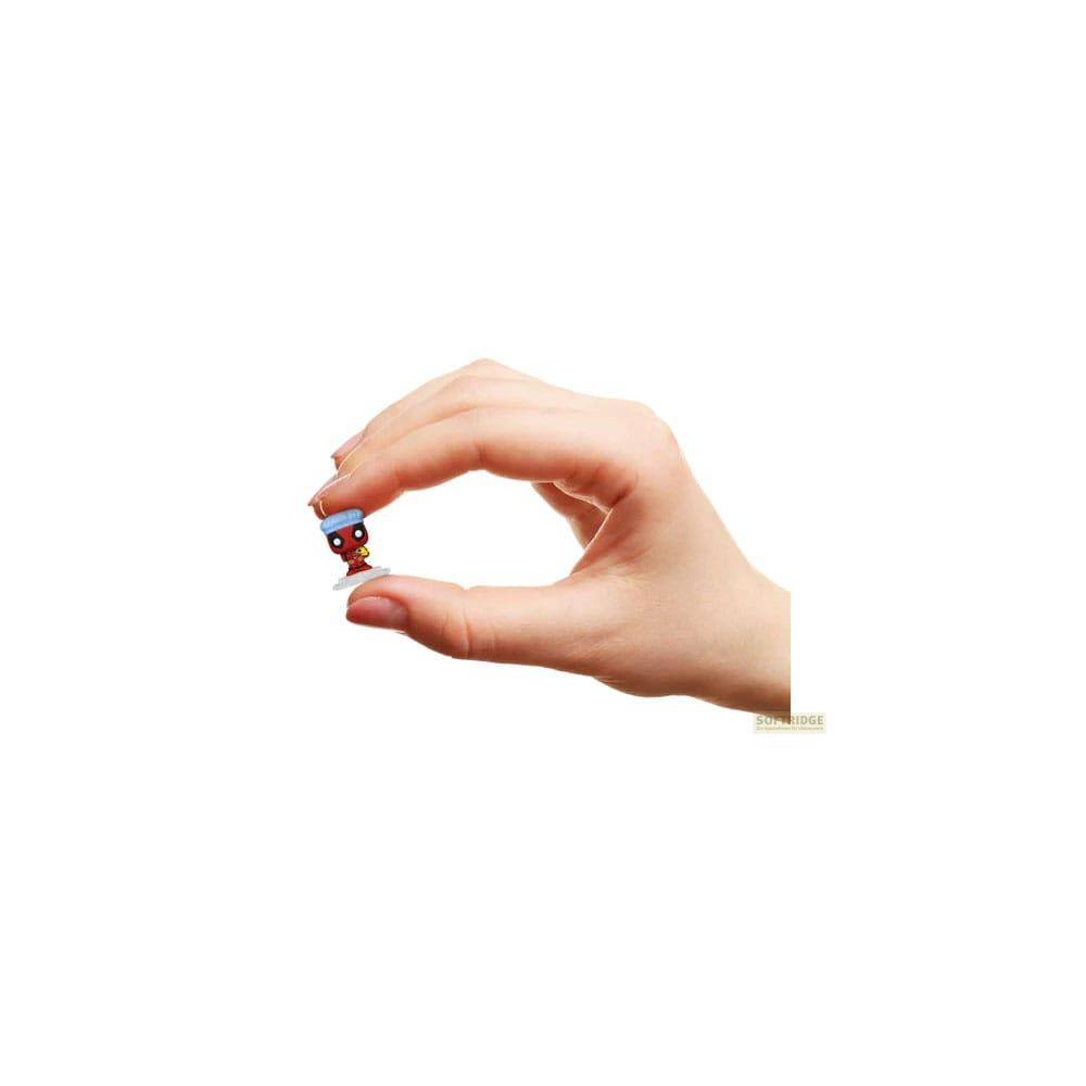 Una mano sostiene una figura roja diminuta con sombrero azul y base blanca.