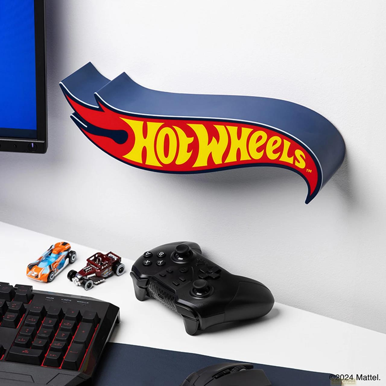 Półka z logo Hot Wheels z kontrolerem, klawiaturą i samochodzikami.