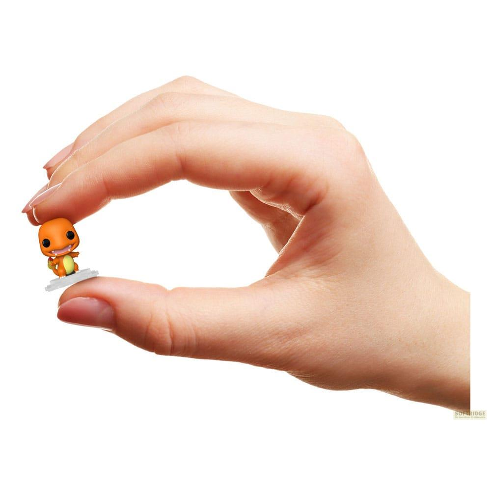 Ein winziges orangefarbenes Glumanda-Spielzeug wird zwischen Daumen und Zeigefinger gehalten.