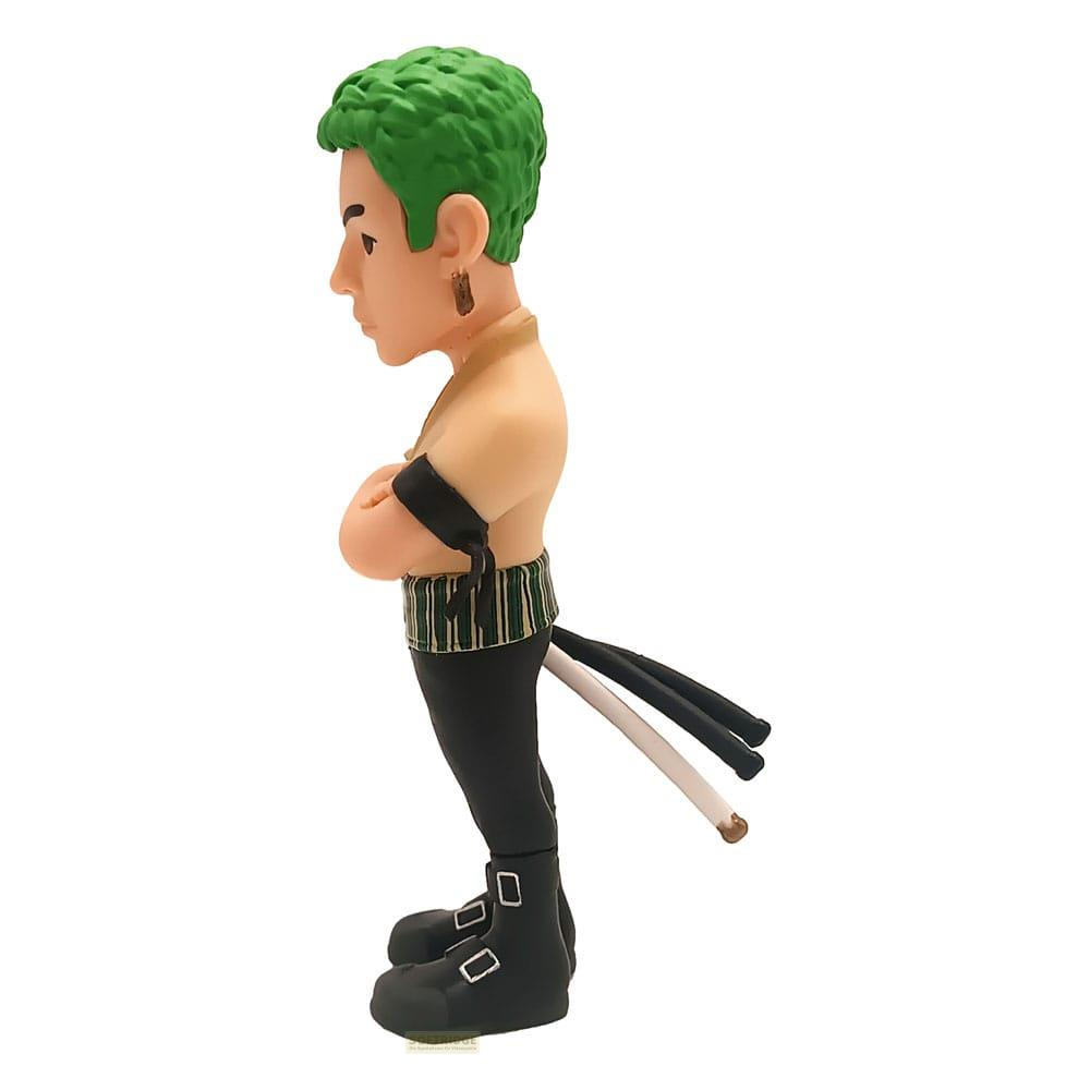 Una figura de un hombre con pelo verde, brazos cruzados, pantalones y botas negros.