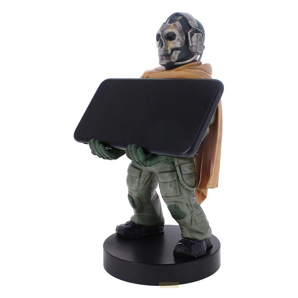 Una statuetta di un soldato con maschera da teschio che tiene un tablet nero su un piedistallo nero.
