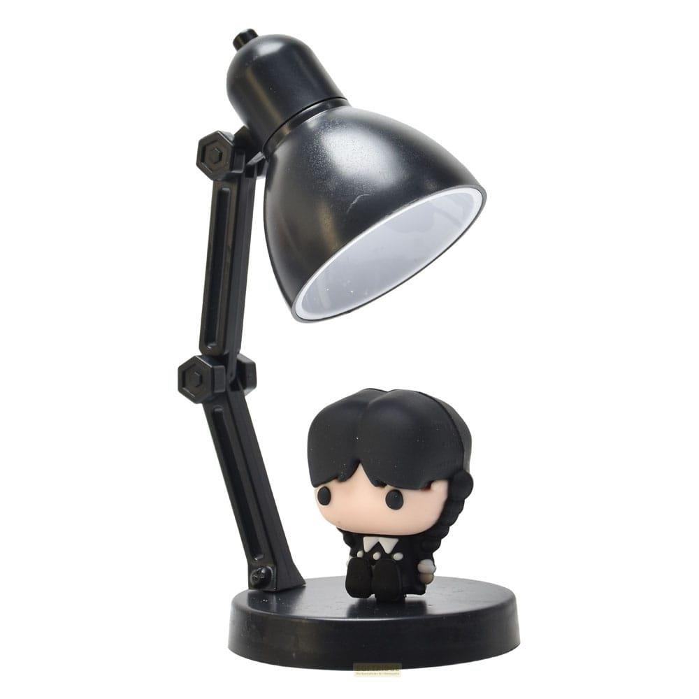 Una lámpara de escritorio negra con una pequeña figura de Wednesday Addams en su base.