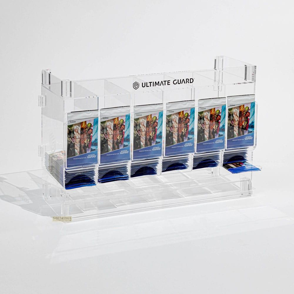 Espositore in acrilico trasparente con logo Ultimate Guard, pieno di bustine.