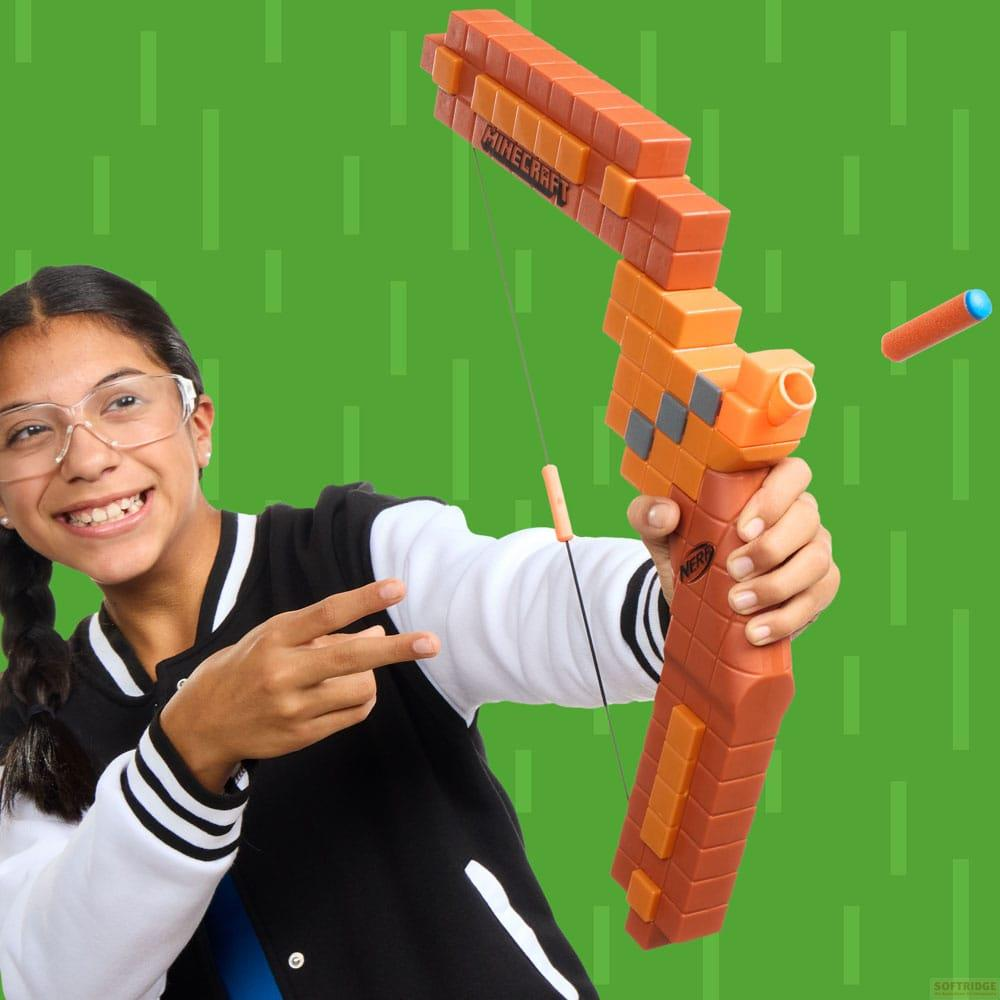 Una niña sonriente con gafas sostiene un arco Nerf naranja de Minecraft. Un dardo vuela cerca.