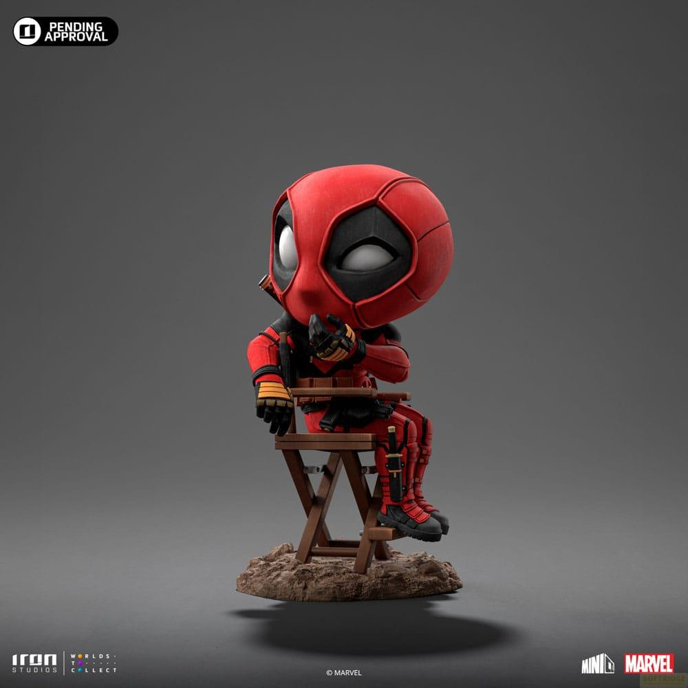 Statua Chibi di Deadpool seduta su sedia di legno, con tuta rossa e nera.