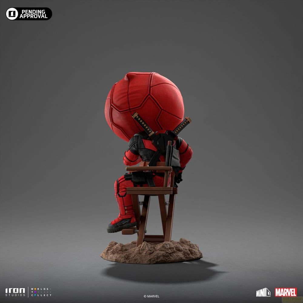 Statua Chibi di Deadpool in tuta rossa seduta su una sedia con spade sulla schiena. Testa a palla rossa.