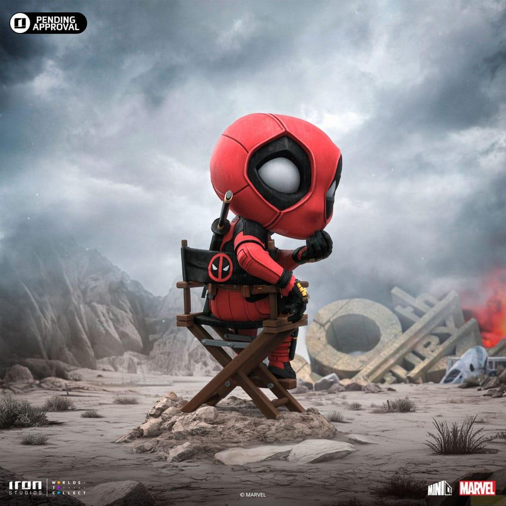 Deadpool Chibi seduto pensieroso su una sedia da regista in un paesaggio polveroso e in rovina.