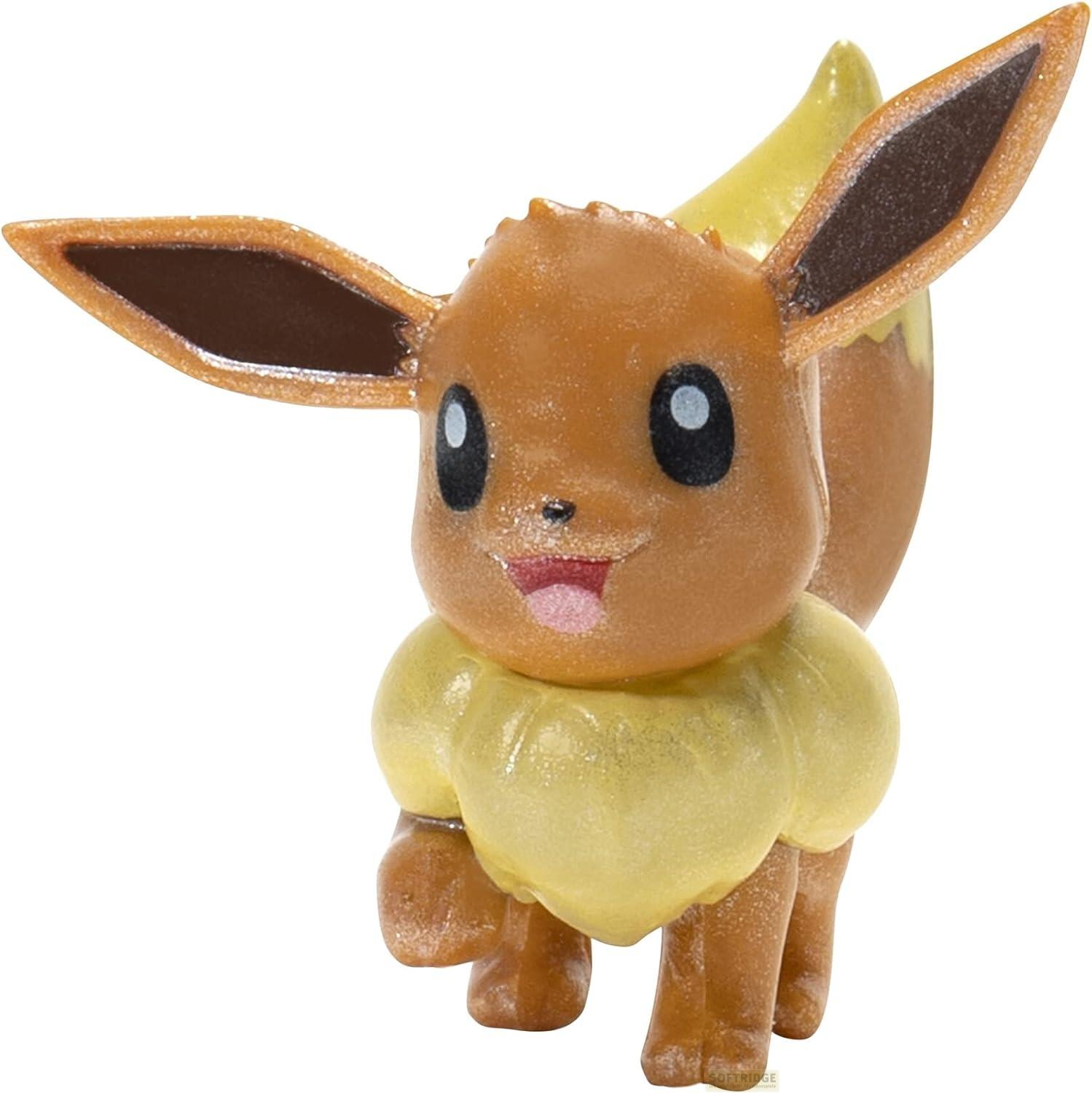 Eine braune Eevee-Figur mit großen Ohren und einem flauschigen gelben Kragen steht vor weißem Hintergrund.